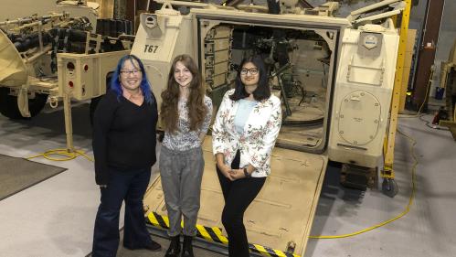 Students with site mentor in front of machine