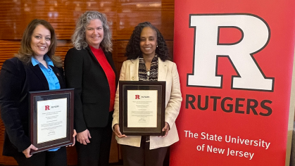 Douglass WiSE and Dean Rehbein in front of "R" Rutgers sign with awards 