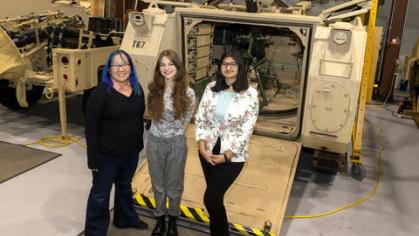 Students with site mentor in front of machine