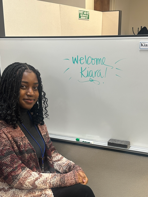 Student at externship in front of welcome sign