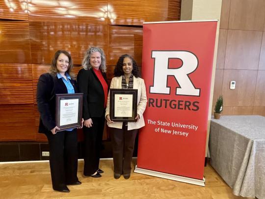 Douglasss WiSE Staff and Dean Rehbein in front of Rutgers Sign and Holding Awards