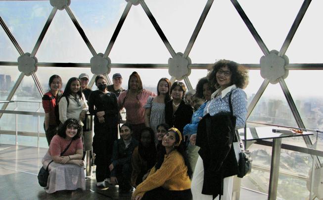 Students take picture in front of glass