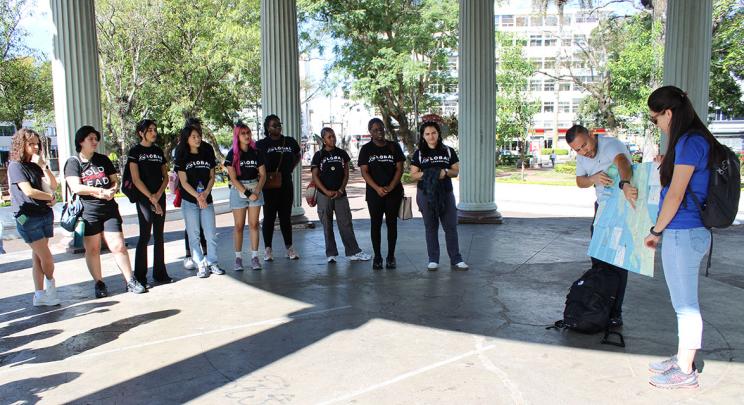 Students listen to guide pointing at map