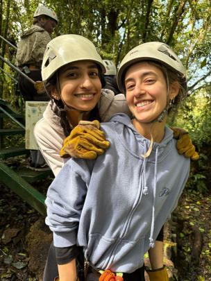 Two students with helmets and gloves smile for photo