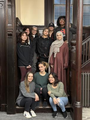 Students and faculty pose for photo on steps