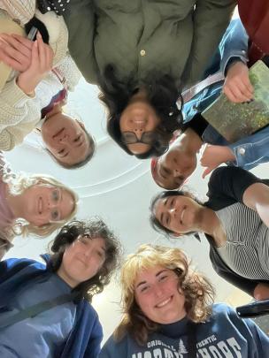 Students stand over camera