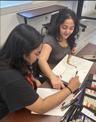 Two students work on art project