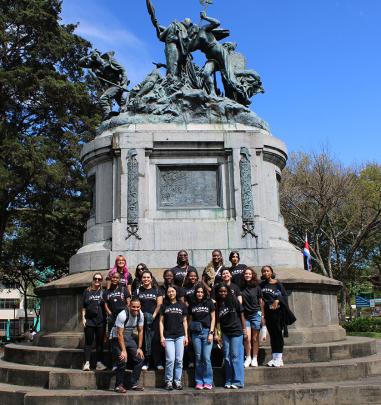 Students stand in front of statue