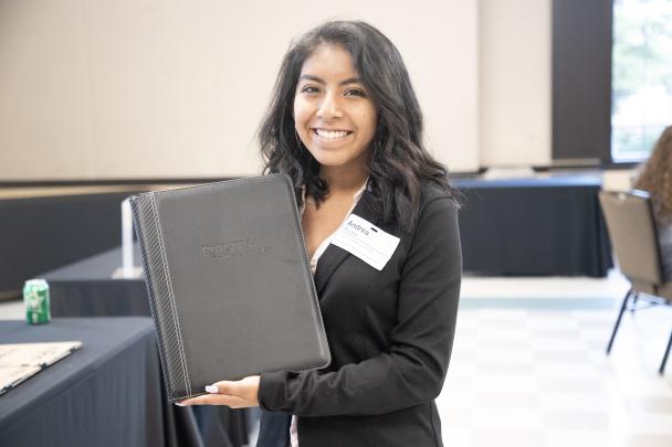 Student holds up folder