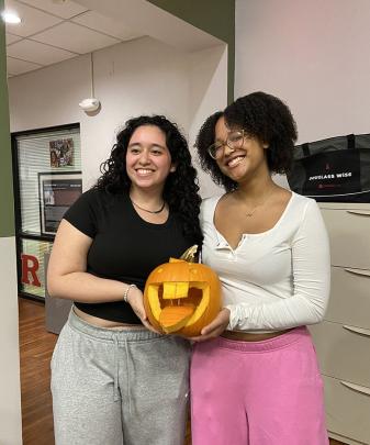 Students holding carved pumpkin