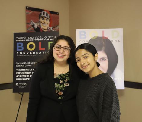 2 students stand in front of sign
