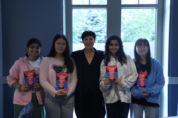 Students hold book with author