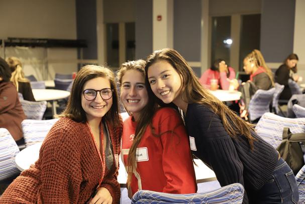 group of three poses for photo