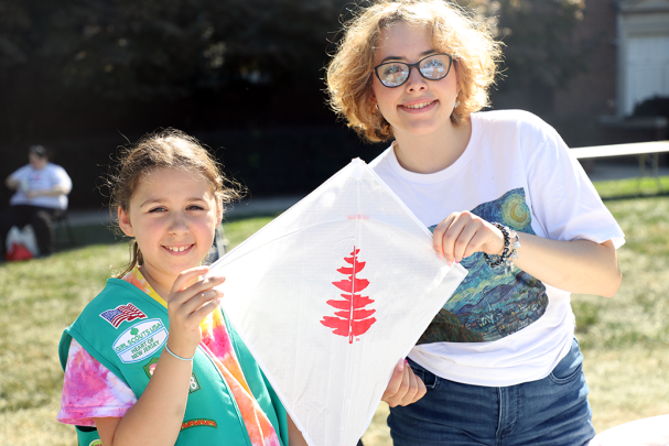 Student and kid holding kite at event
