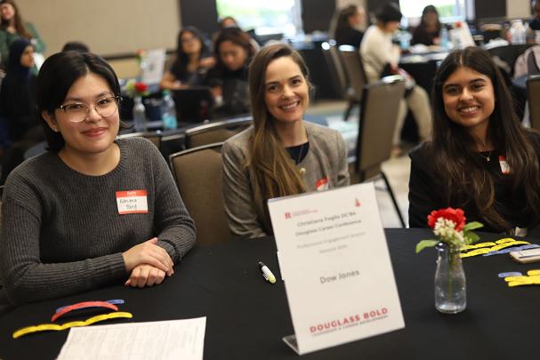 Faculty and students sit at table